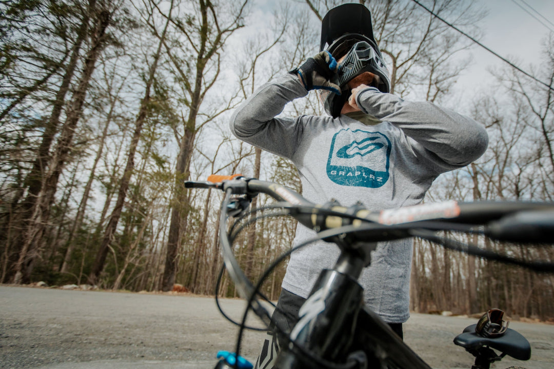 Man in motorcycle helmet wearing heather gray Topo Long Sleeve Tee