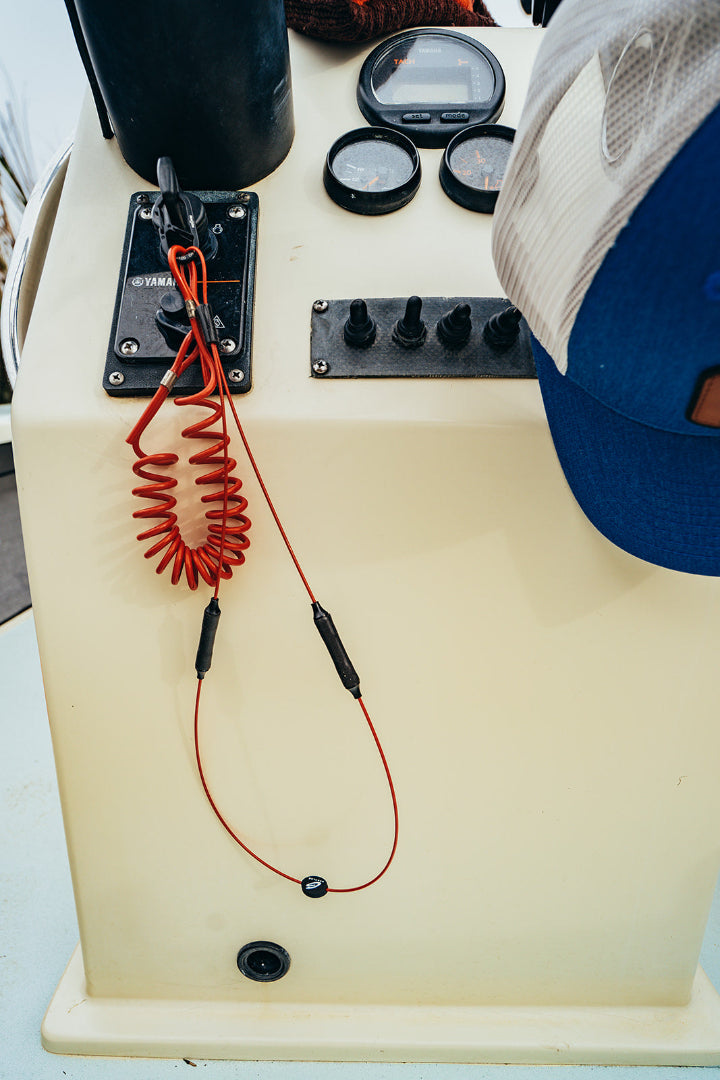 Boat controls with keys in ignition clipped to orange GRAPLRZ VERZA Multi Use Lanyard