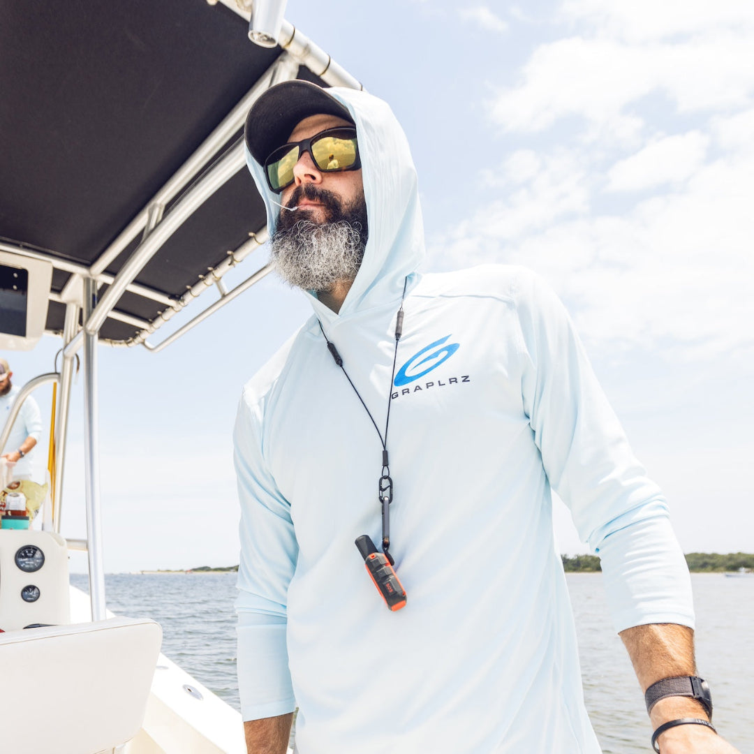 Bearded man in blue hoodie and sunglasses wearing GRAPLRZ VERZA Multi Use Lanyard around his neck