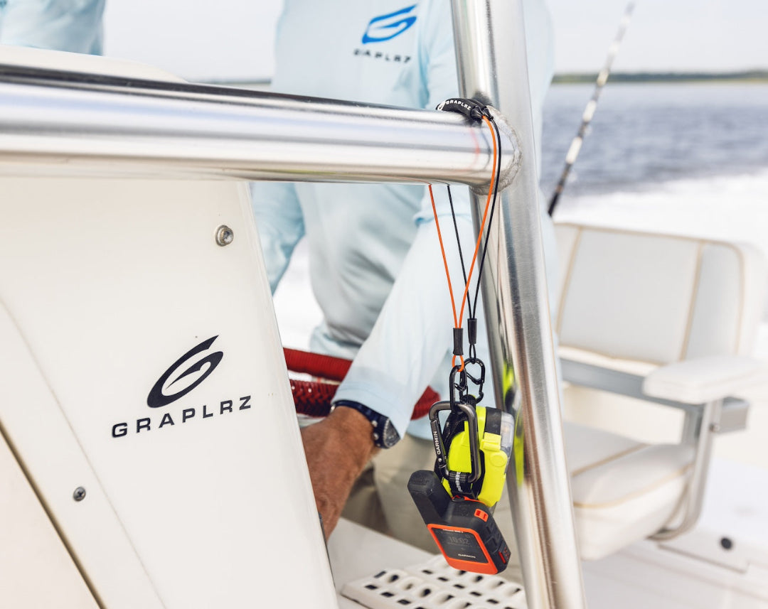 Two GRAPLRZ Verza Mini Utility Lanyards clipped to various items, hanging from pipes on a boat