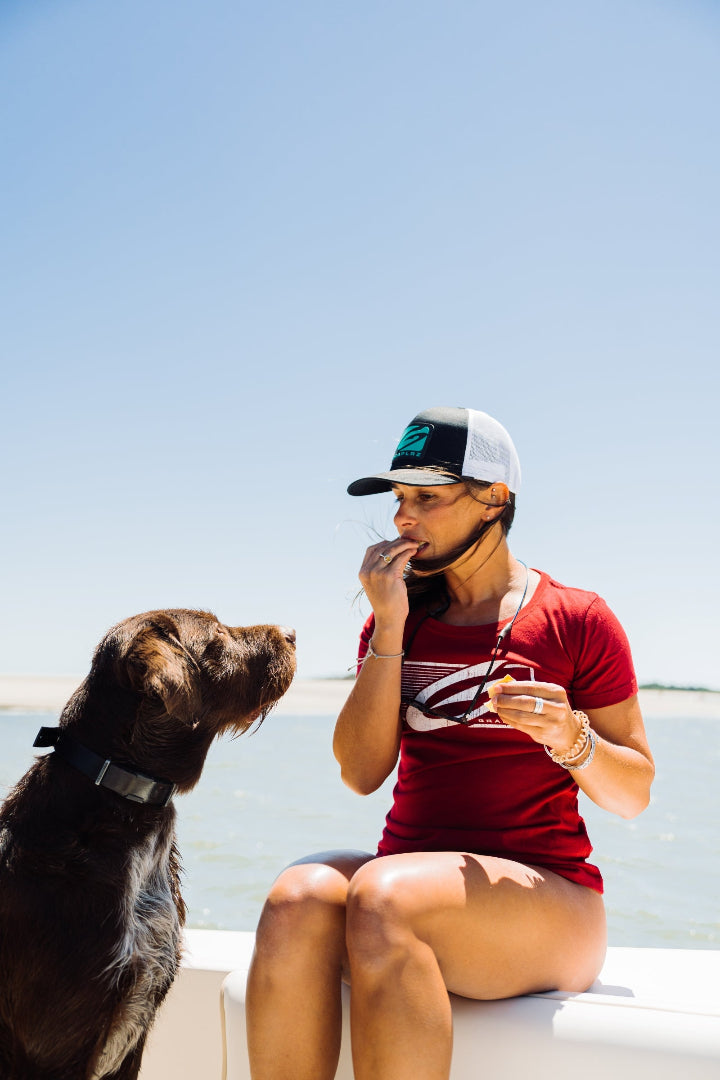 Woman in Dark Red GRAPLRZ Trailblazer tee in front of a dog
