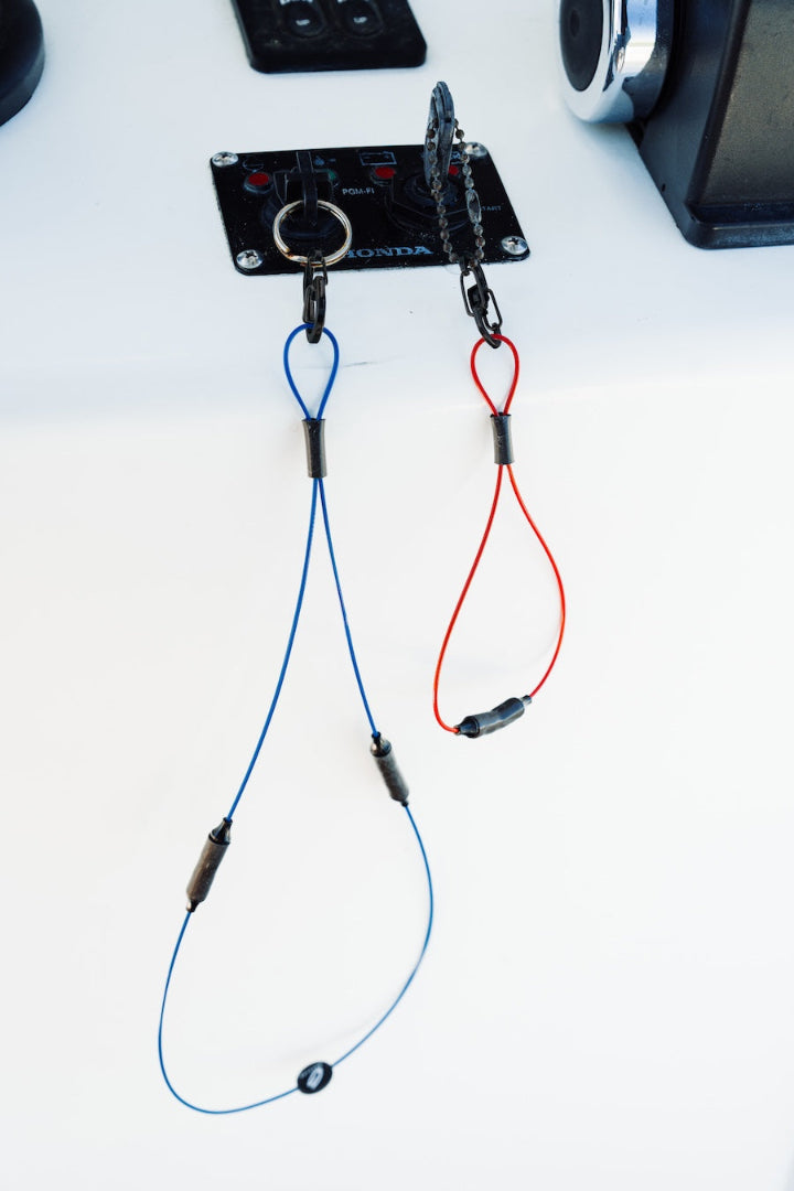 Boat ignition with two pairs of keys attached to blue GRAPLRZ VERZA Multi Use Lanyard and orange Verza Mini Utility Lanyard