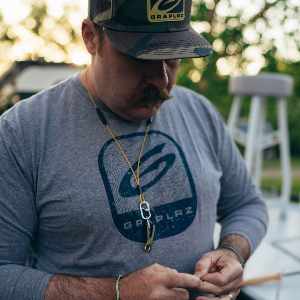 Man in blue long sleeved GRAPLRZ shirt and yellow GRAPLRZ VERZA Multi Use Lanyard around his neck