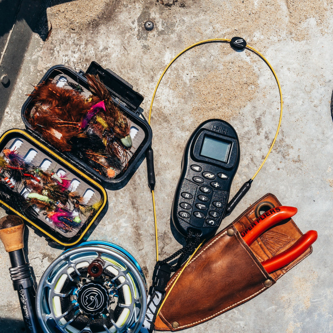 Yellow GRAPLRZ VERZA Multi Use Lanyard surrounded by various fishing items